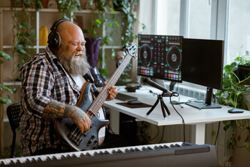 Emotional obese man plays electric guitar in home audio studio