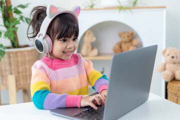 Smiling little Asian girl have a video call distant class with teacher using laptop, social distance during quarantine isolation during the Coronavirus