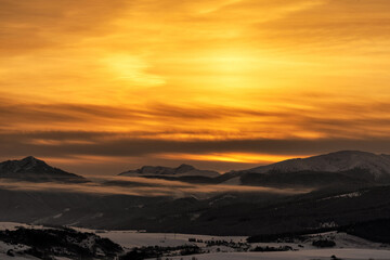Fototapeta na wymiar Snowy winter mountain landscape and colorful sky due sunrise over hills Sina, Dumbier and Chopok in Low Tatras mountains at Slovakia