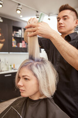 Fototapeta premium Attractive young woman getting haircut in beauty salon
