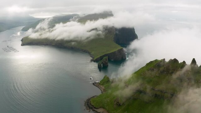 Aerial view of Drangarnir cliff and Tindholmur islands in foggy weather. Faroe