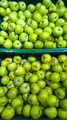 Pile of green apples background in box. Grocery store. Shelves with natural fruits in supermarket or local farmers market. Food. Retail industry. Discount price. Greengrocers shop. Inflation concept.