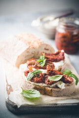 Bruschetta with sundried tomatoes, cottage cheese and fresh basil. Tasty savory Italian appetizers