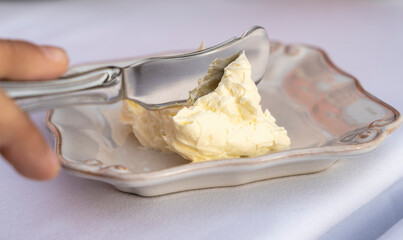 Fresh salted butter from homemade production. Knife with butter to spread. Butter that looks like cream. Delicious food. Fat food with high calories