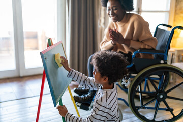 Happy woman with disability learning together with a child. People education fun concept