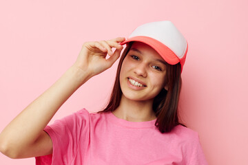 cheerful young girl with a cap on her head in a pink t-shirt