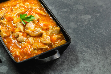 Chicken goulash in cast iron skillet. Top view, copy space.