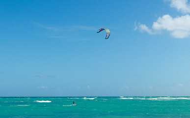 Turquoise ocean blue sky and kiteboarding.