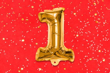 The number of the balloon made of golden foil, the number one on a red background with sequins. Birthday greeting card with inscription 1. Top view. Numerical digit, Celebration event, template.