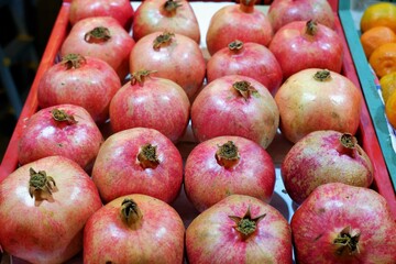 pomegranates lined up in a crate in a large food market in Budapest, Hungary