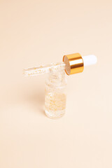 Dropping serum gold collagen moisturizer of face soft light background. Protector skin Treatment...