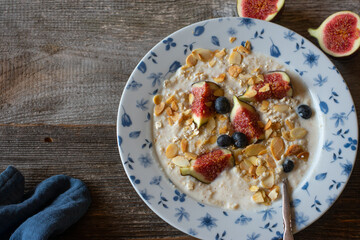 Healthy breakfast with porridge, figs, blueberries and almonds 