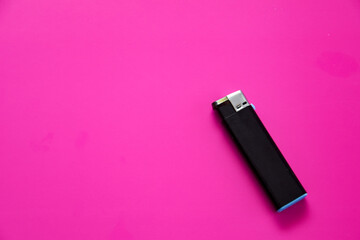 Black gas lighter on a purple background. Close-up surface for your design. Empty gas plastic lighter mockup element. Close-up shot, top view.