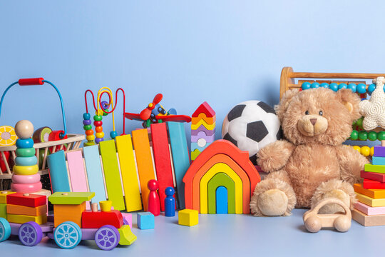 Baby kid toys collection isolated on blue background. Teddy bear, wooden, plastic and fluffy educational baby toy set. Front view
