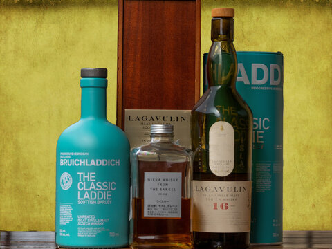 Bottles of excellent fine whiskeys. Lagavulin, Nikka and Bruichladdich with their packaging.