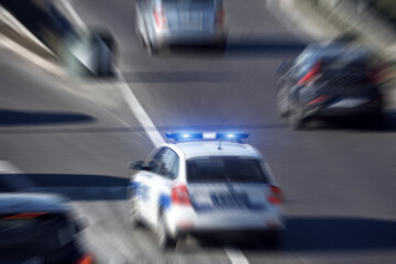 Police car with blue lights moving fast in traffic urban environment.