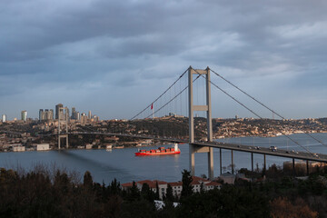 A very beautiful Istanbul bosphorus and bridge view in sunrise. A trade ship under the bridge. Morning light.