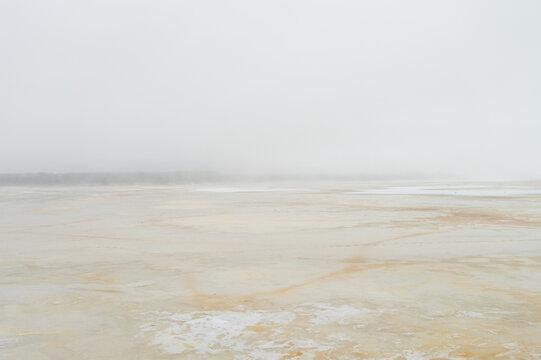 Abstract misty serene winter scene over frozen lake. Blurred background. Defocused image