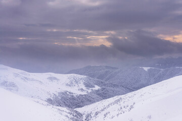 Fototapeta na wymiar Snow-covered mountain slopes at sunset. Winter landscape. Carpathian Mountains.