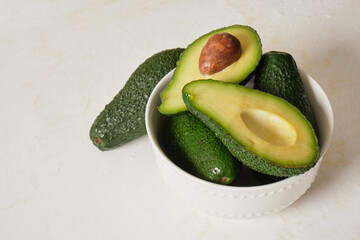 avocado in a bowl on a light texture background