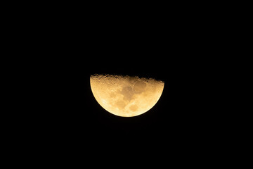 The half moon, luna at night isolated on black background. Nature