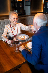Elegant woman smiling while her partner kisses her hand