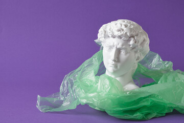david head in transparent plastic bag on purple background, art decline, environmental pollution slices concept