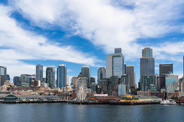 Seattle skyline with waterfront and Great wheel view. Skyscrapers of financial downtown at day time, Washington, USA. A vibrant business neighborhood