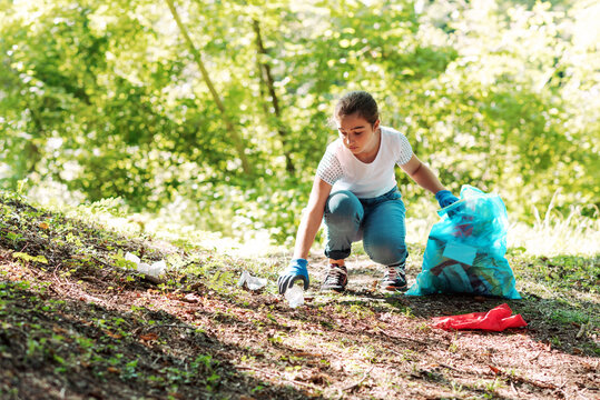 Young volunteer cleaning up a forest