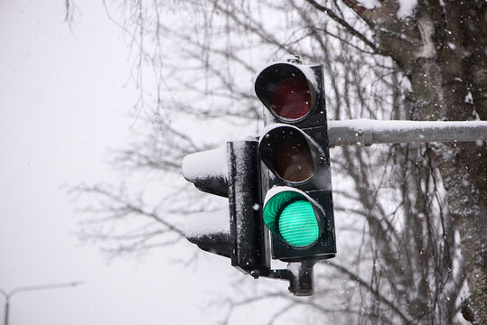 Green traffic light in semaphore during winter snowy day