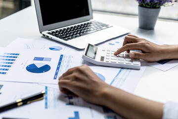 Businesswoman using a white calculator, a financial businessman examining the numerical data on a...