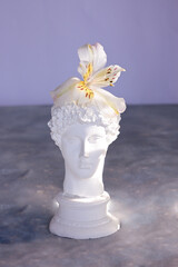 Plaster sculpture of a young guy with flowers
