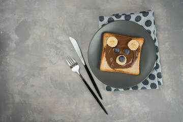 Kids breakfast or lunch or snack toast with chocolate hazelnut spread, banana and blueberry shaped...