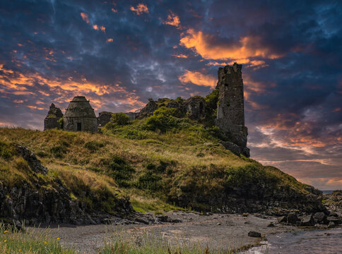 The Ancient Dunure Castle Ruins and Rugged Defences Crumbling Onto the Shore and a Dramatic Sunset.