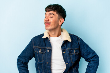 Young mixed race man isolated on blue background dreaming of achieving goals and purposes