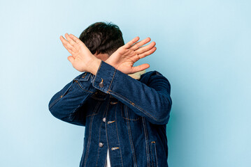 Young mixed race man isolated on blue background keeping two arms crossed, denial concept.