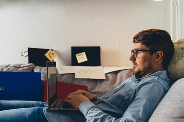 Young freelancer working on laptop at home
