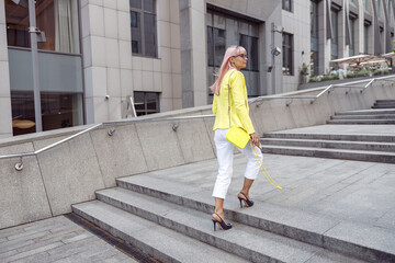 Female with pink hair going up city stairs