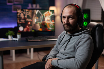 Portrait of man preparing to play video games on computer. Gamer with headphones getting ready to...