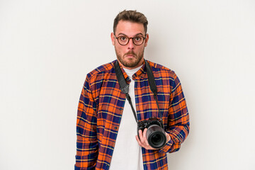 Young caucasian photograph man isolated on white background shrugs shoulders and open eyes confused.