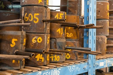 Metal molds for the production of various shapes of glass products lie on the shelves in the factory or glass manufacture.