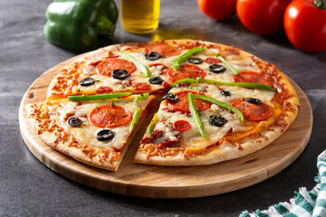 Traditional supreme pizza on black background