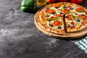 Traditional supreme pizza on black background. Copy space