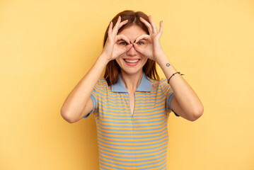 Young English woman isolated on yellow background excited keeping ok gesture on eye.