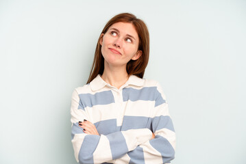 Young English woman isolated on blue background dreaming of achieving goals and purposes