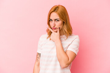 Young caucasian woman isolated on pink background contemplating, planning a strategy, thinking about the way of a business.