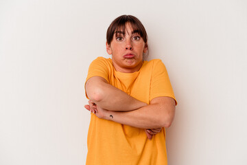 Young Argentinian woman isolated on white background shrugs shoulders and open eyes confused.