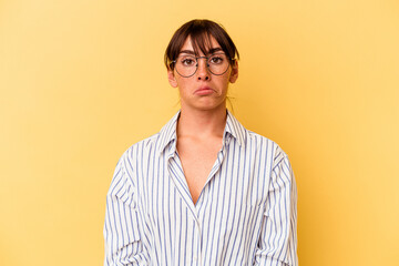 Young Argentinian woman isolated on yellow background sad, serious face, feeling miserable and displeased.