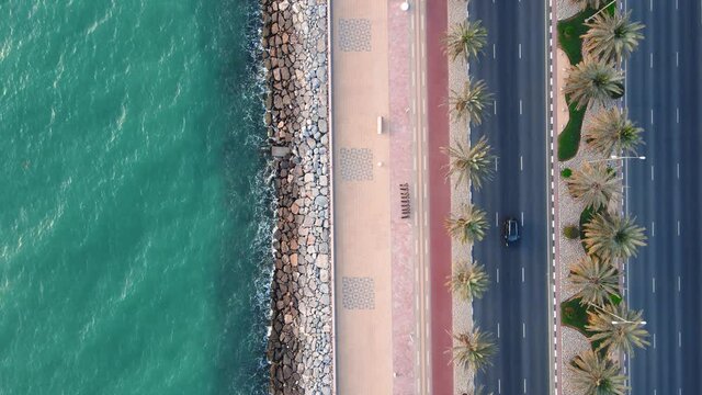 Coastal road with palm trees and running track in Marjan Island in Ras al Khaimah emirate of UAE
