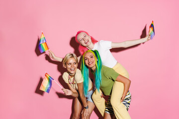 Young three women making fun with rainbow flags together